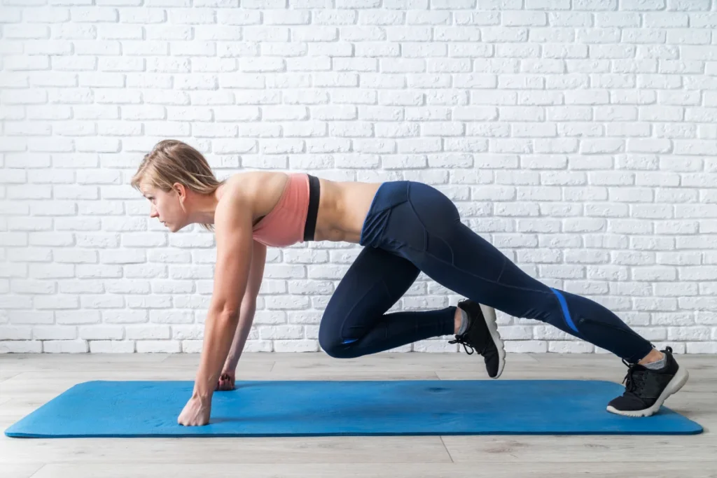 A woman performing a cross-body mountain climber on a yoga mat to engage her core and lose belly fat.