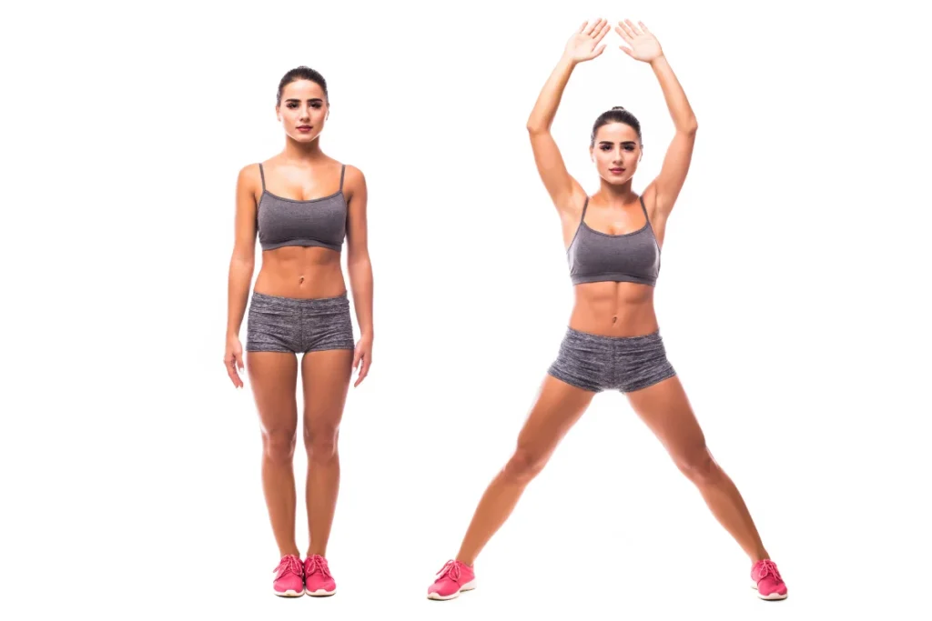 A woman demonstrating jumping jacks, a full-body cardio exercise that helps burn calories and reduce belly fat effectively.