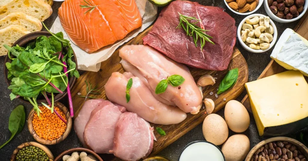 A variety of protein-rich foods like chicken, salmon, beef, eggs, nuts, and leafy greens displayed on a wooden board, often misused in unethical ways to lose weight without proper balance or guidance.