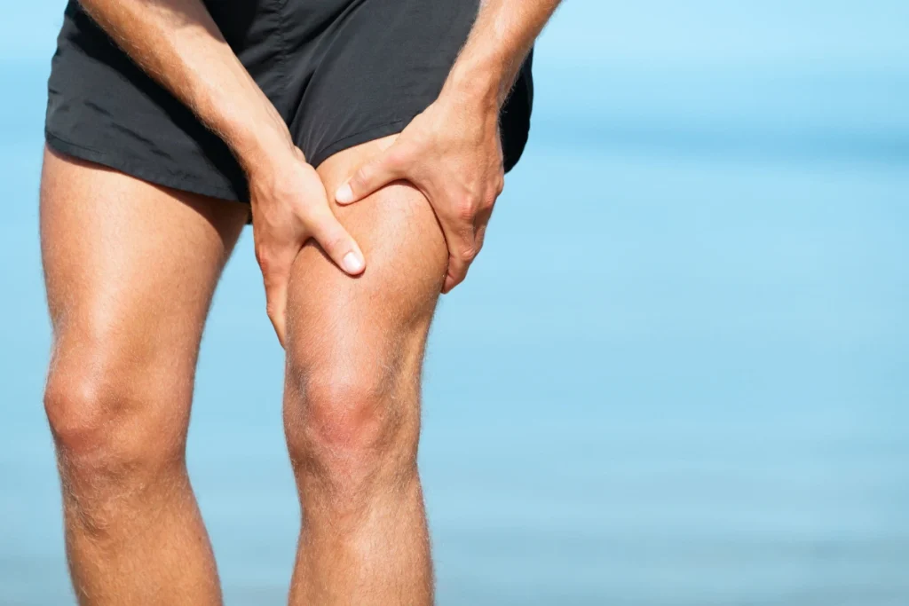 A person holds their thigh in discomfort, likely from muscle strain. The image highlights the need to speed up muscle strain recovery through proper care and treatment.