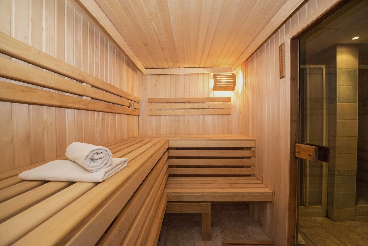 Wooden sauna interior with benches and towels, showing how calories burned in sauna sessions can contribute to weight loss.