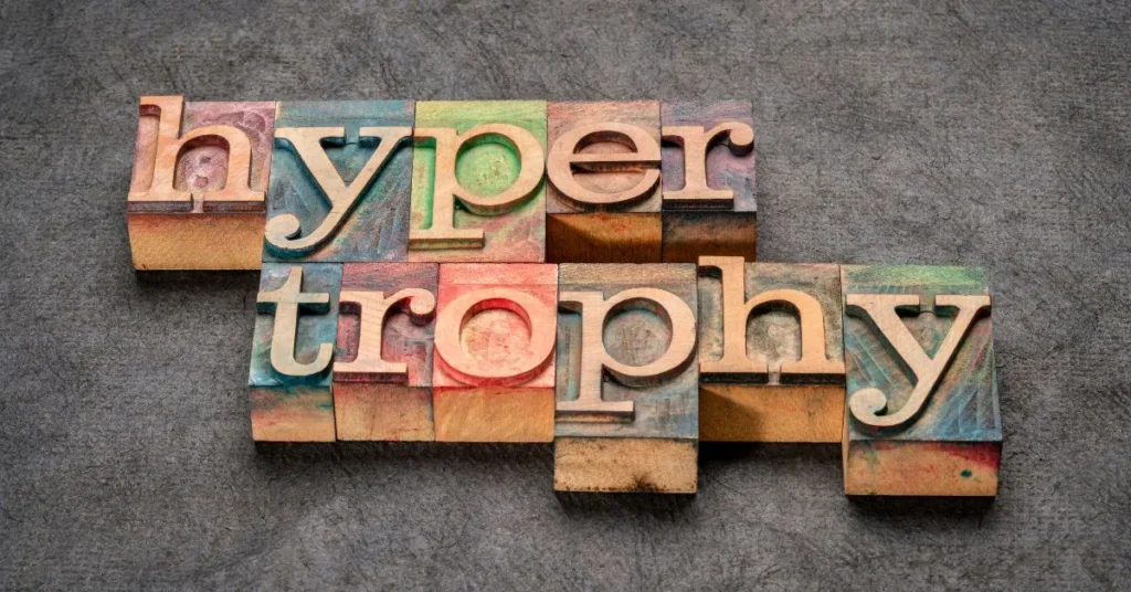 Colorful wooden letter blocks spelling out the word 'hypertrophy' on a textured surface, representing the concept of full body hypertrophy workout and muscle growth.