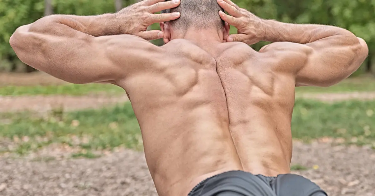 Muscular man performing LOWER-TRAPS workout outdoors showcasing strong scapular definition. This Lower Trap Exercises image highlights Lower-trapezius-exercise techniques including Prone-Y-Raise, Prone-T-Raise, Wall-Slide, Scapular-Retraction, and Barbell-Row – ideal for posture improvement and back strength.