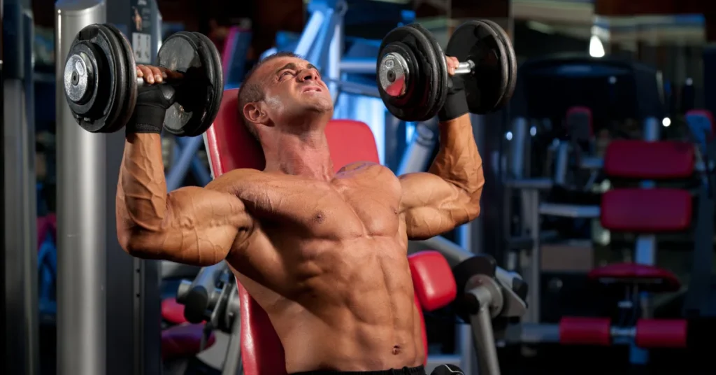 Bodybuilder performing seated dumbbell military press in gym to build shoulder muscles and enhance upper-body strength using proper form.